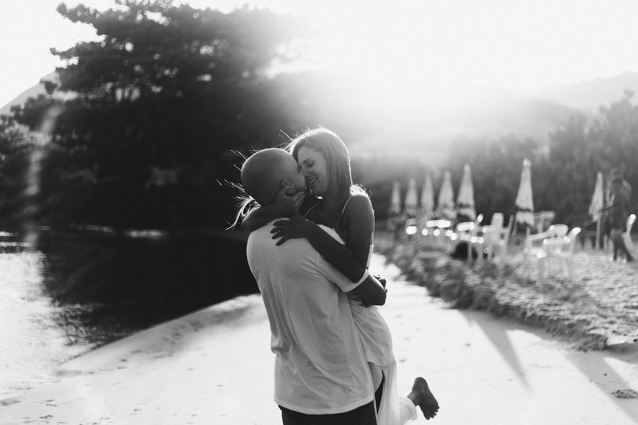 Grayscale Photo of a Couple Holding Each Other Close
